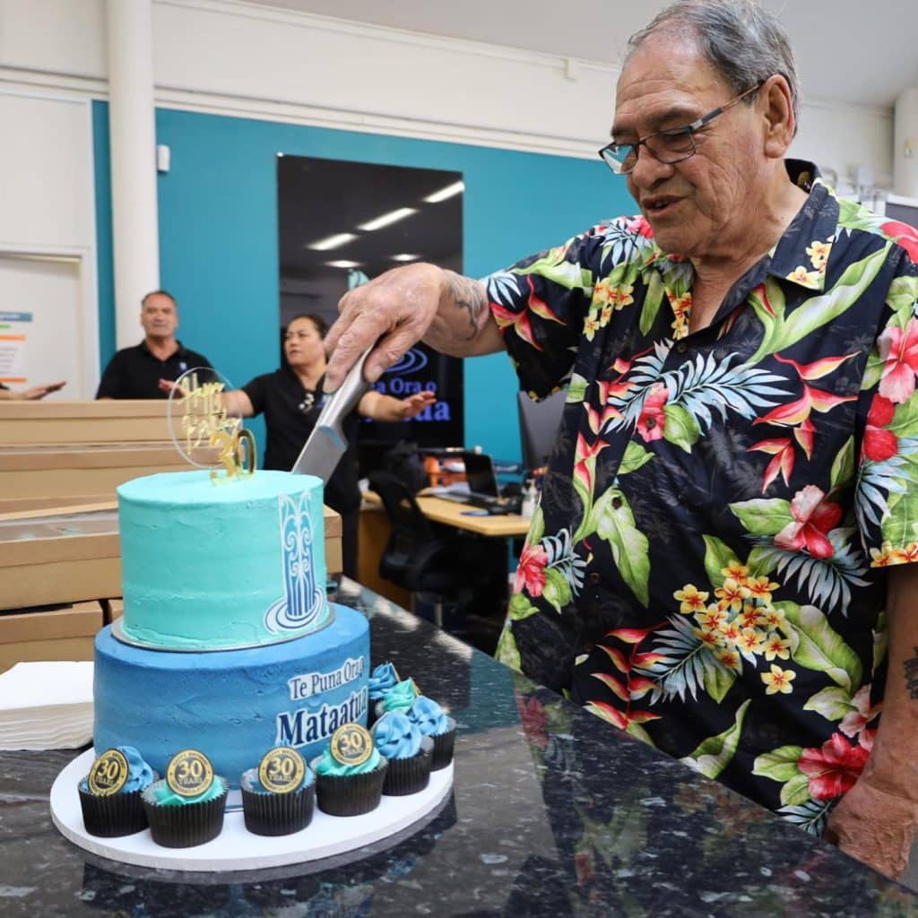 Deputy Chairman Brian Simpson cuts into Te Puna Ora o Mataatua's 30th Birthday Cake